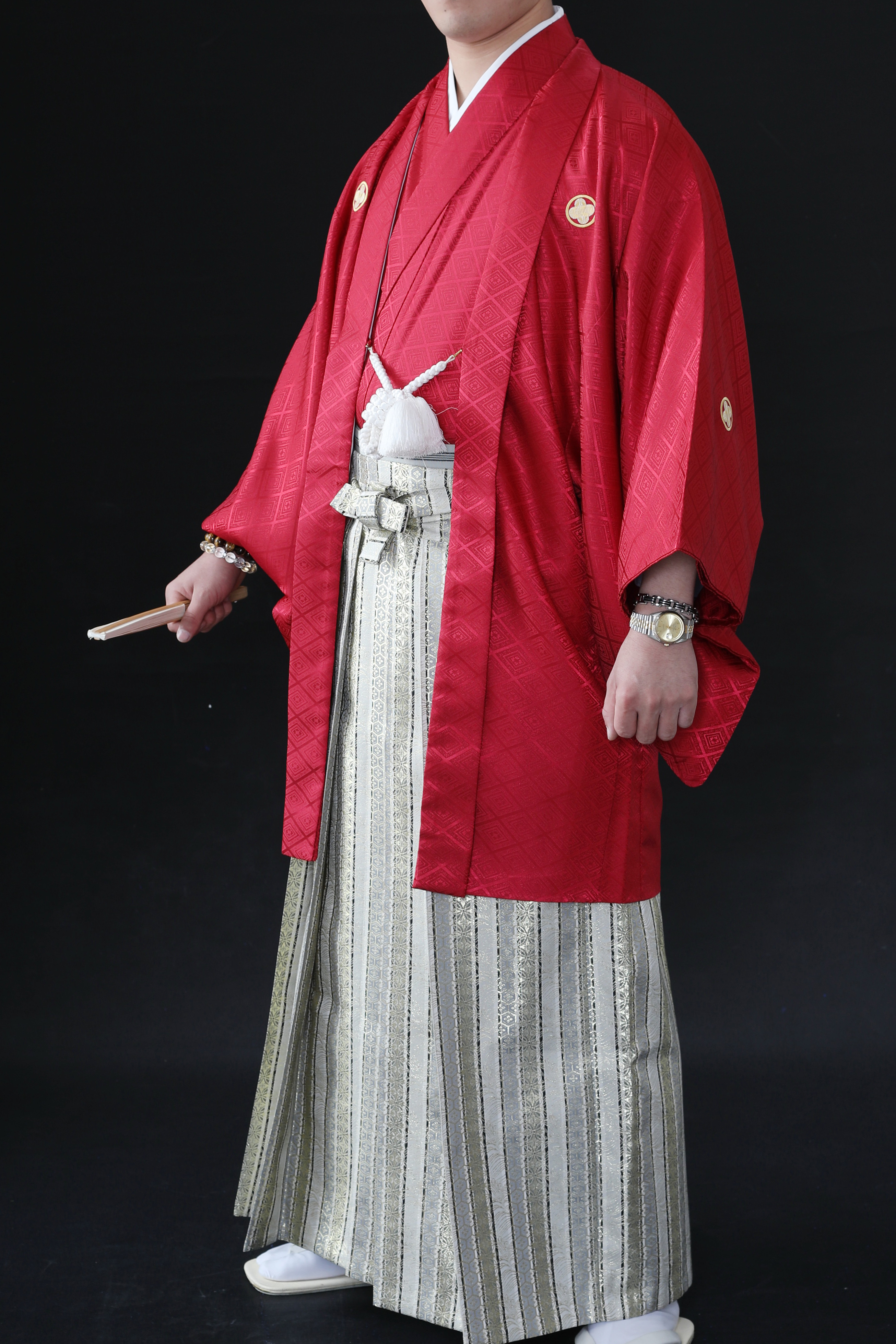 赤の着物とゴールドの袴を着ている男性