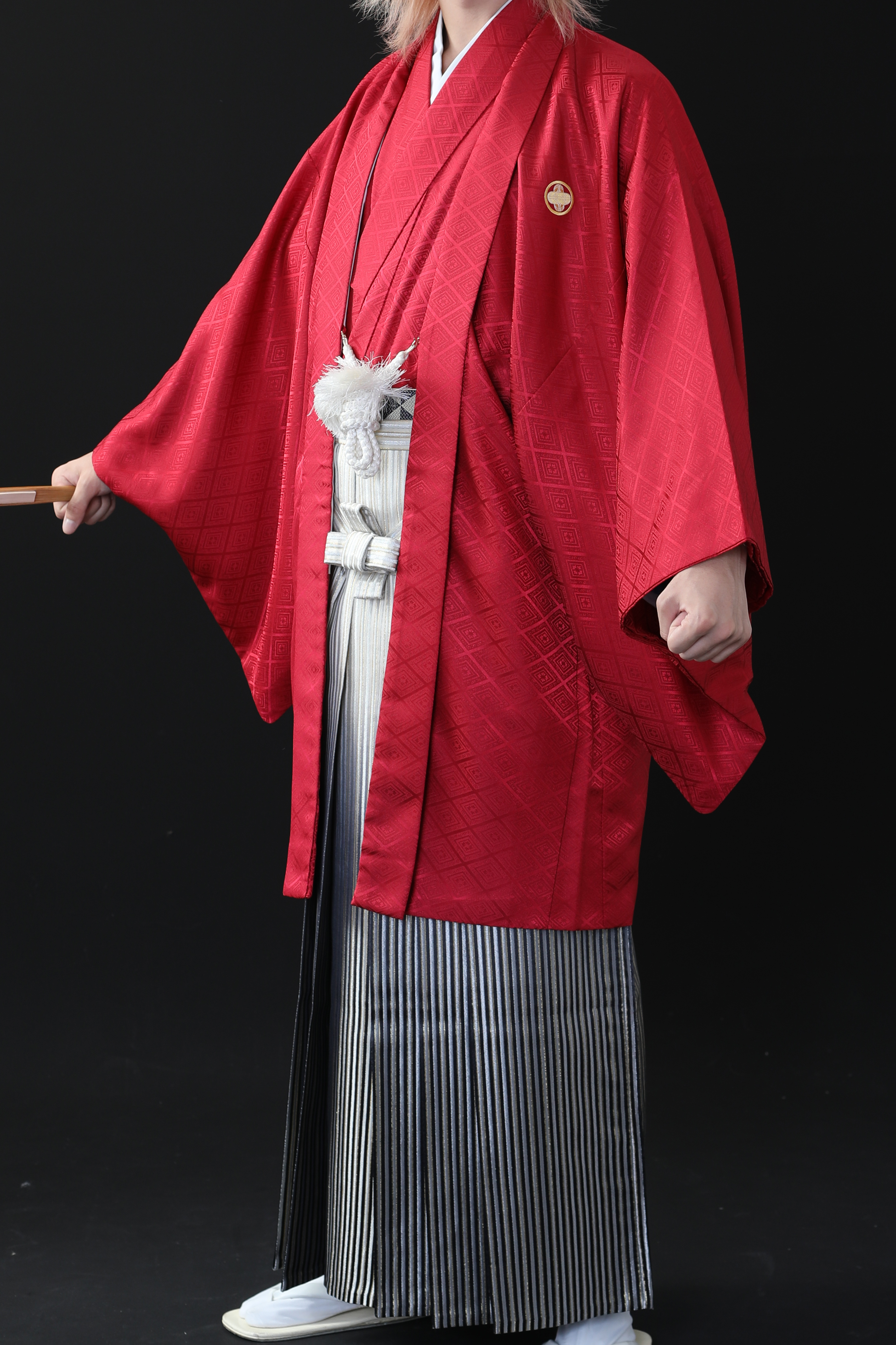 赤の着物とゴールドの袴を着ている男性