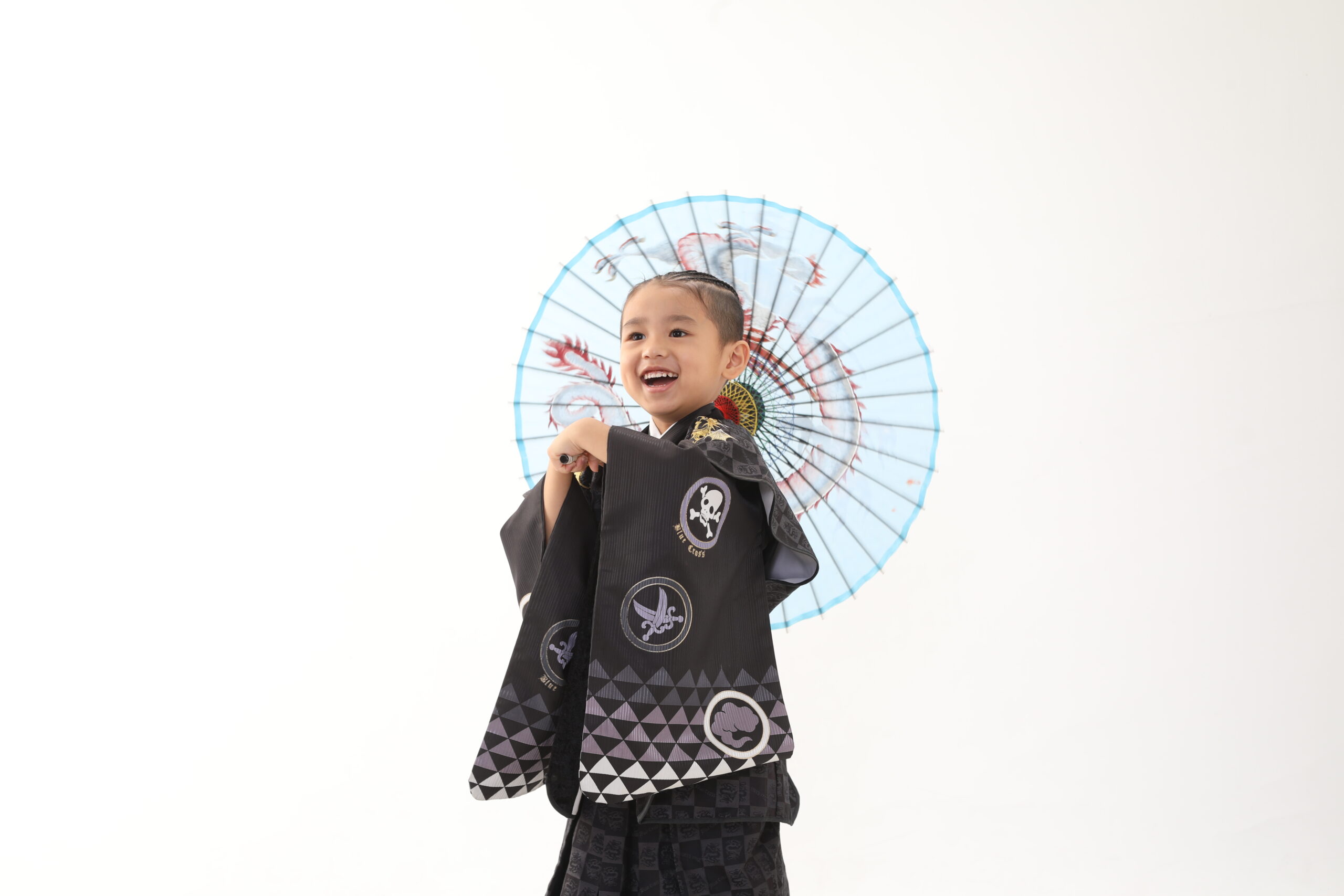青色の傘を持っている黒の着物を着ている5歳の男の子の七五三前撮り写真