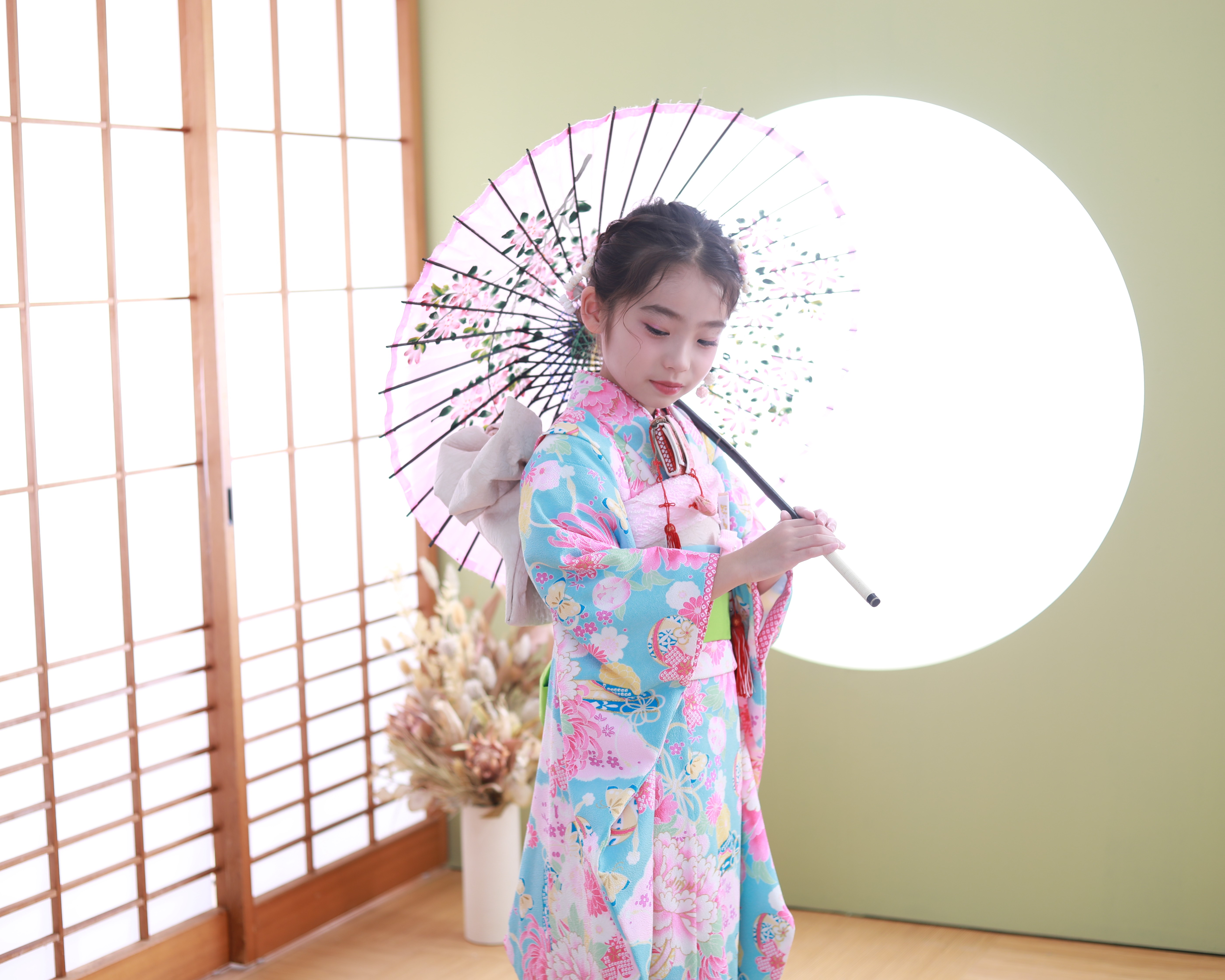 水色の着物を着て和傘を持って撮影した七歳女の子の写真