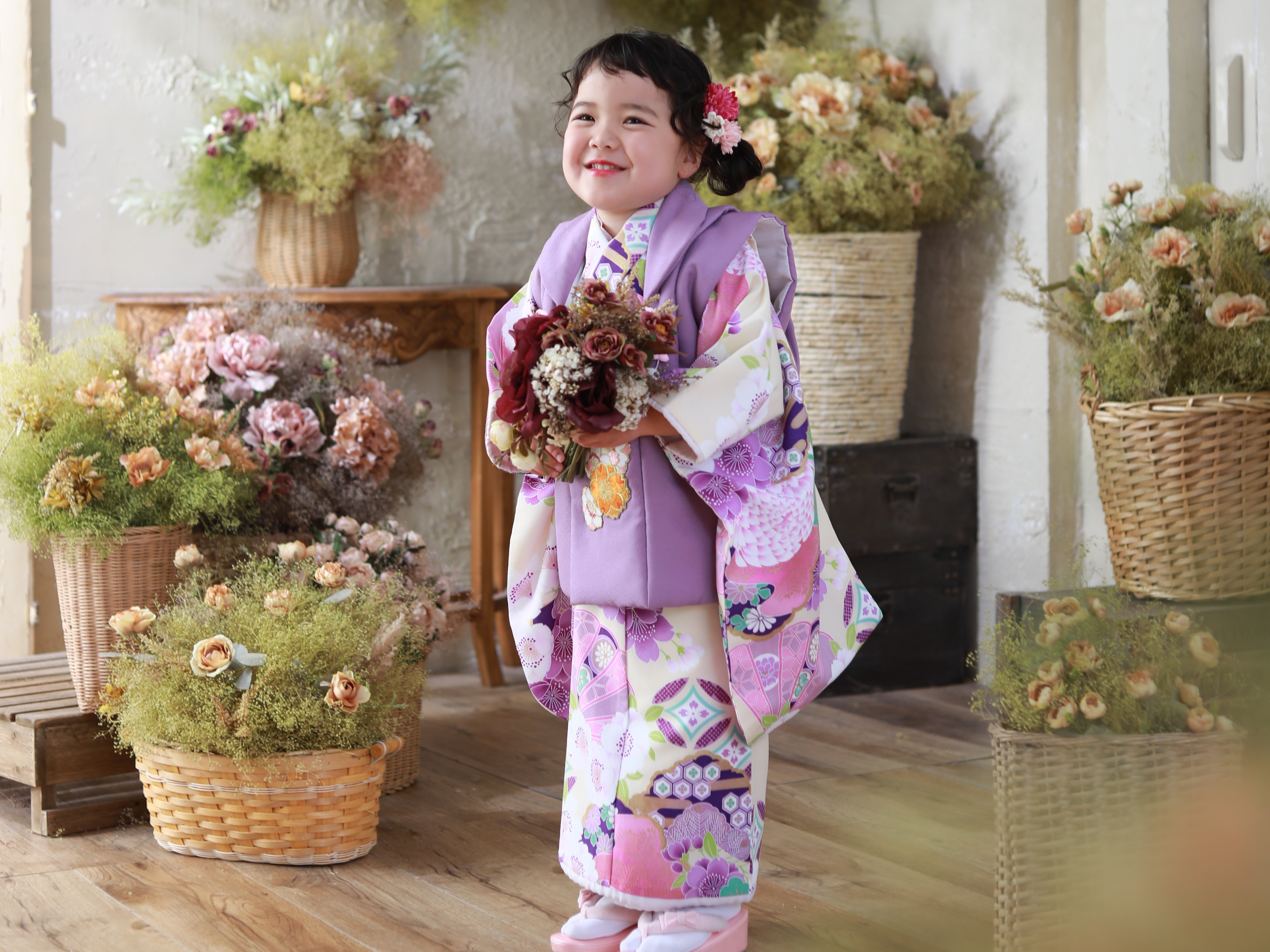 紫の着物を着てブーケを持って三歳女の子の写真