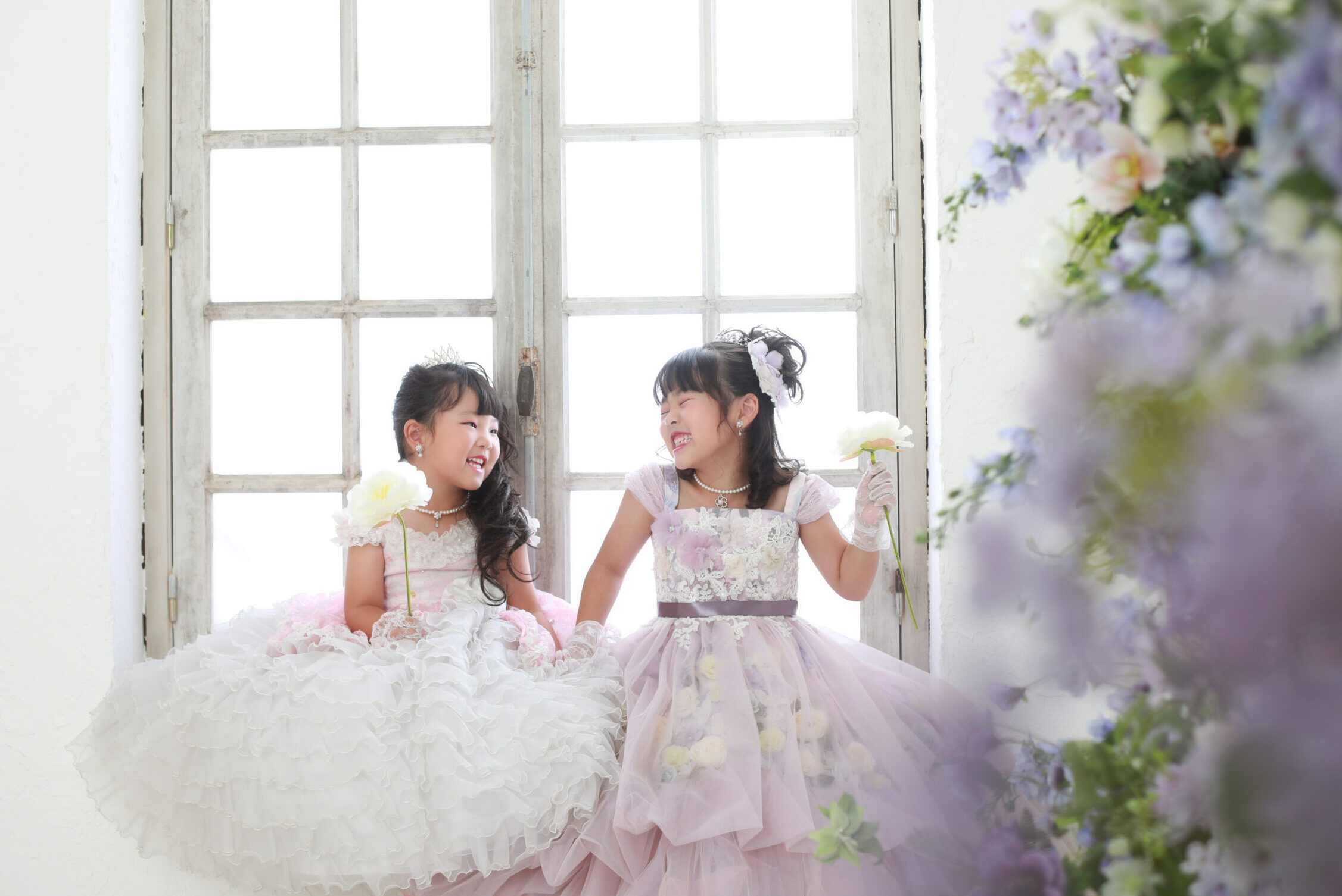 ピンク色のドレスを着た5才の妹と薄紫色のドレスを着た7歳の女の子