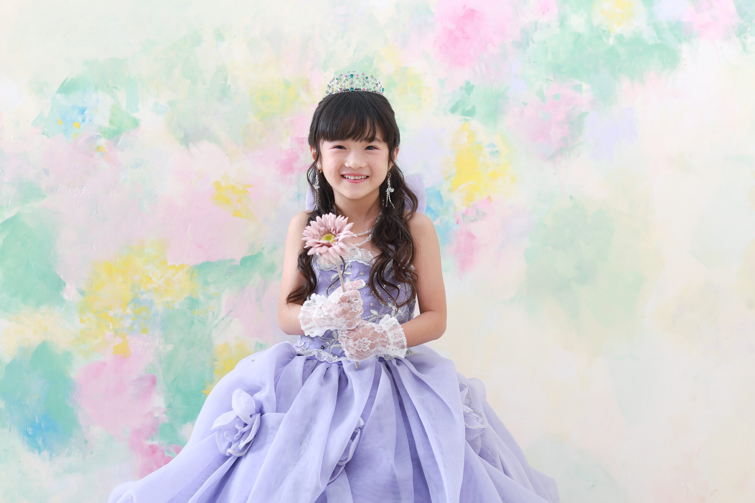 紫のドレスを着て水彩柄のセット背景で撮影した七歳女の子の七五三前撮り写真