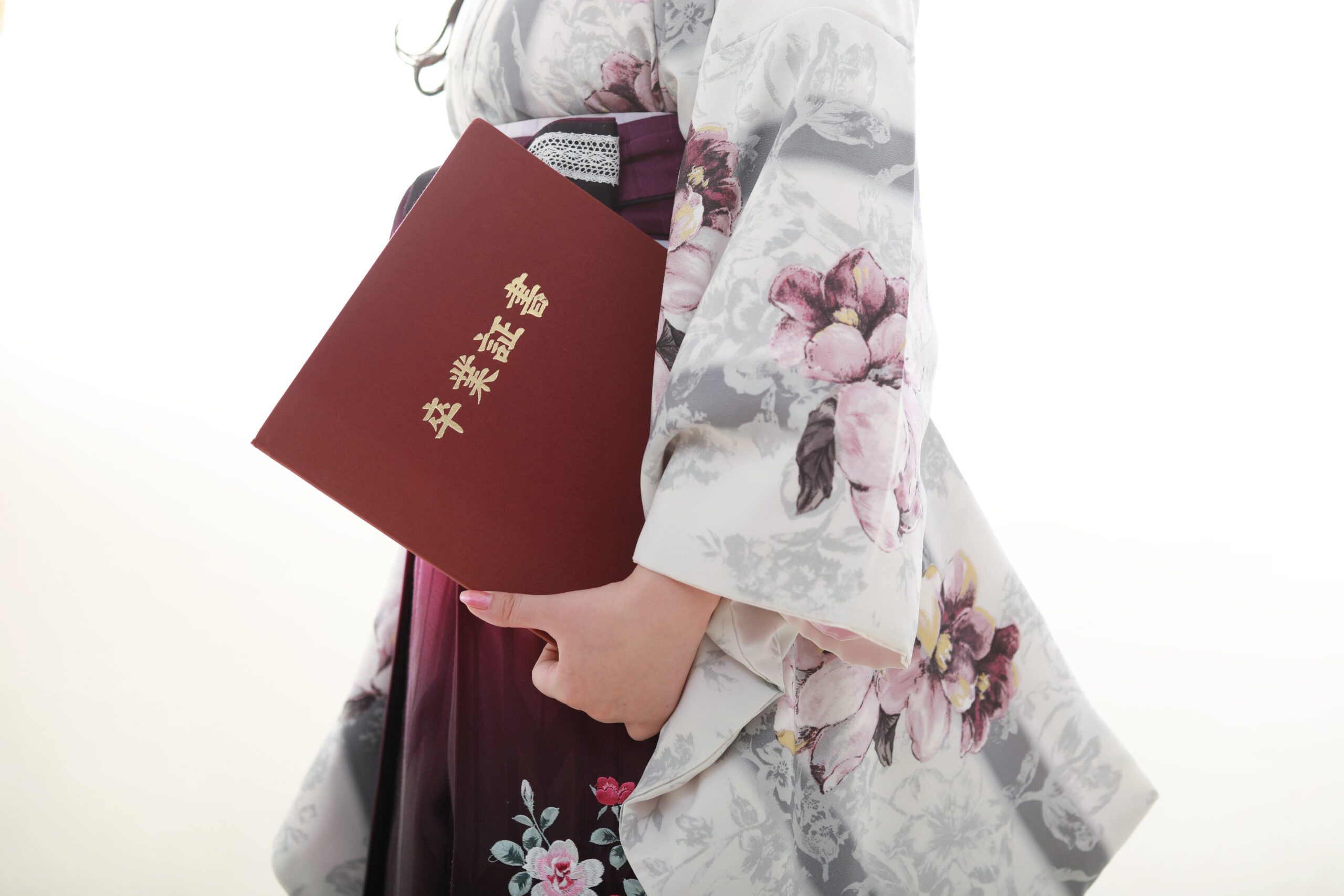 卒業袴前撮りのオフショット　薄グレーの人気着物を着て卒業証書を持ったお嬢様の写真
