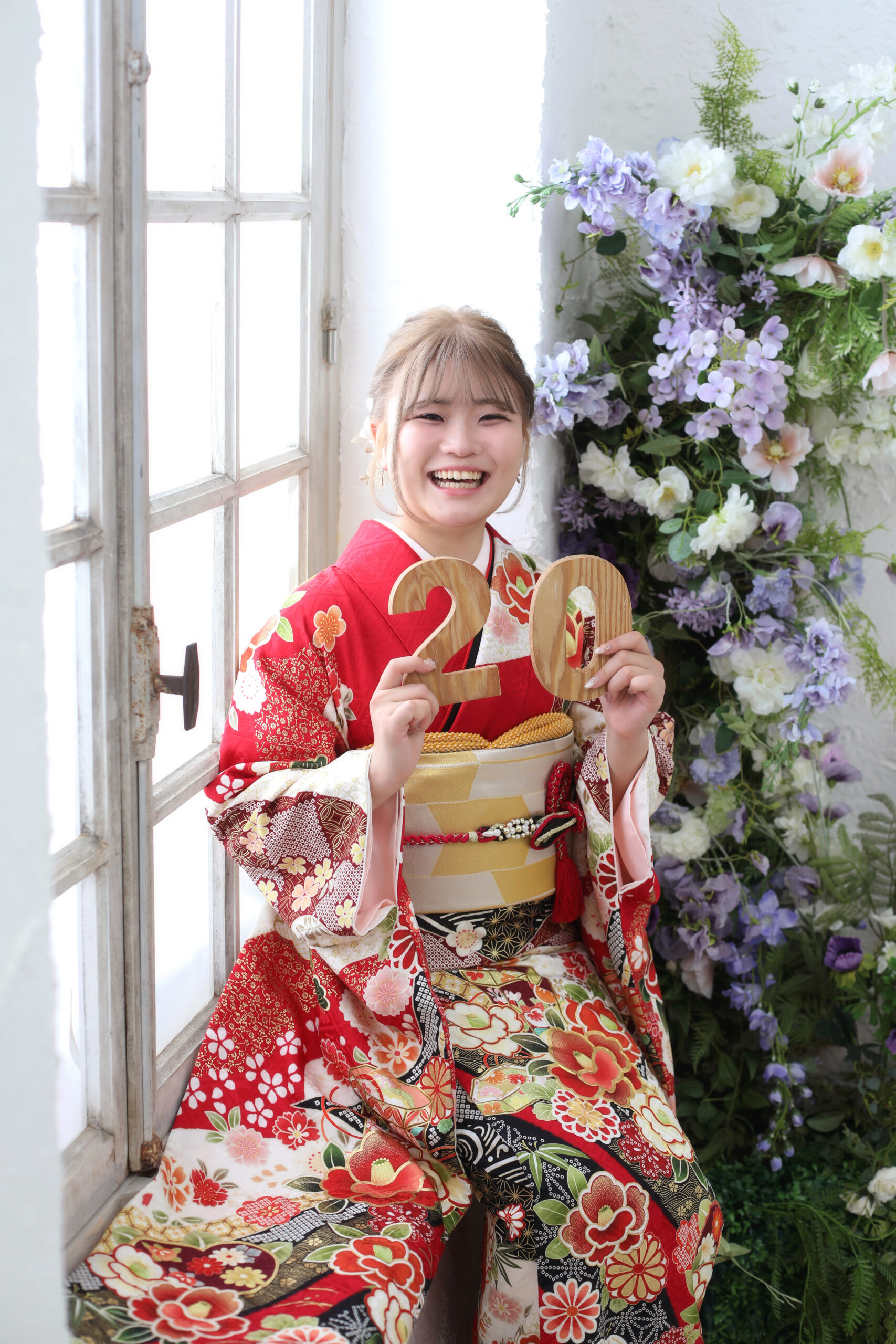 赤色の振袖をきている20歳の女の子の20歳ポーズ