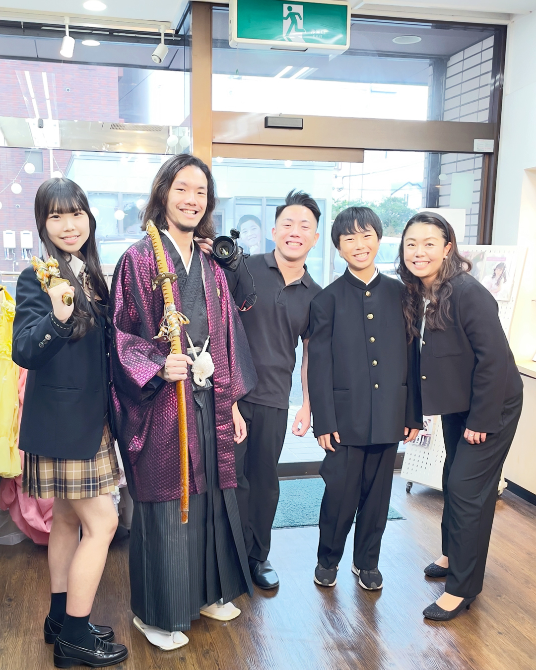 紫色の紋付き袴を着た20歳の男性とその家族とカメラマン