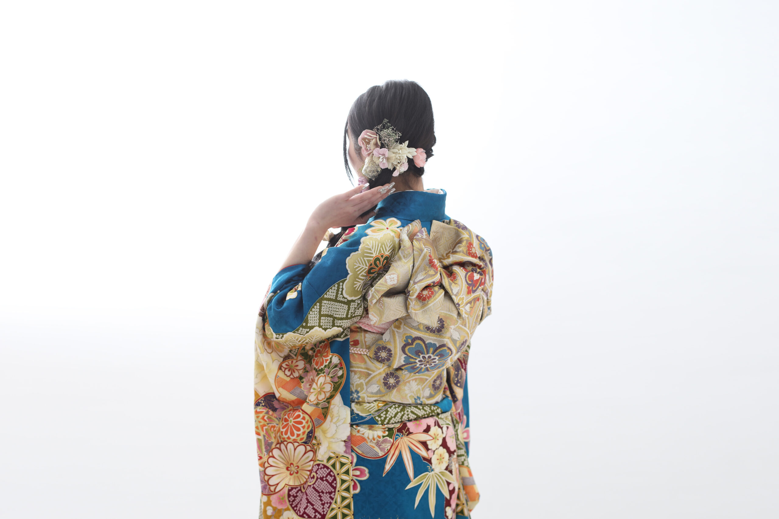 青色の振袖を着た編み下ろしヘアスタイルの20歳の女の子