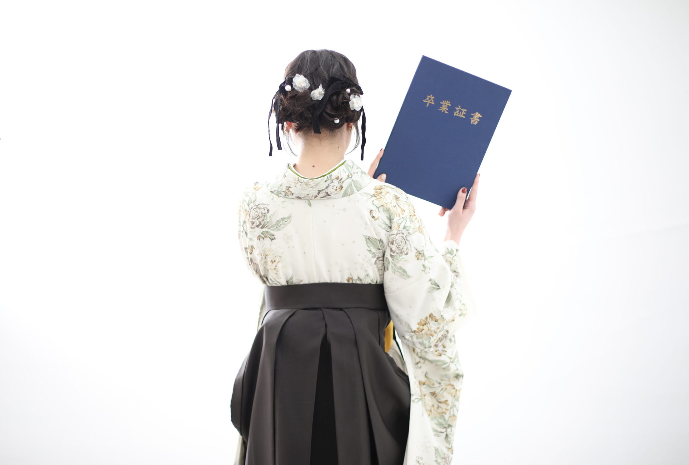 ベージュの着物にチャコールカラーの袴を合わせたコーディネート。後ろ姿