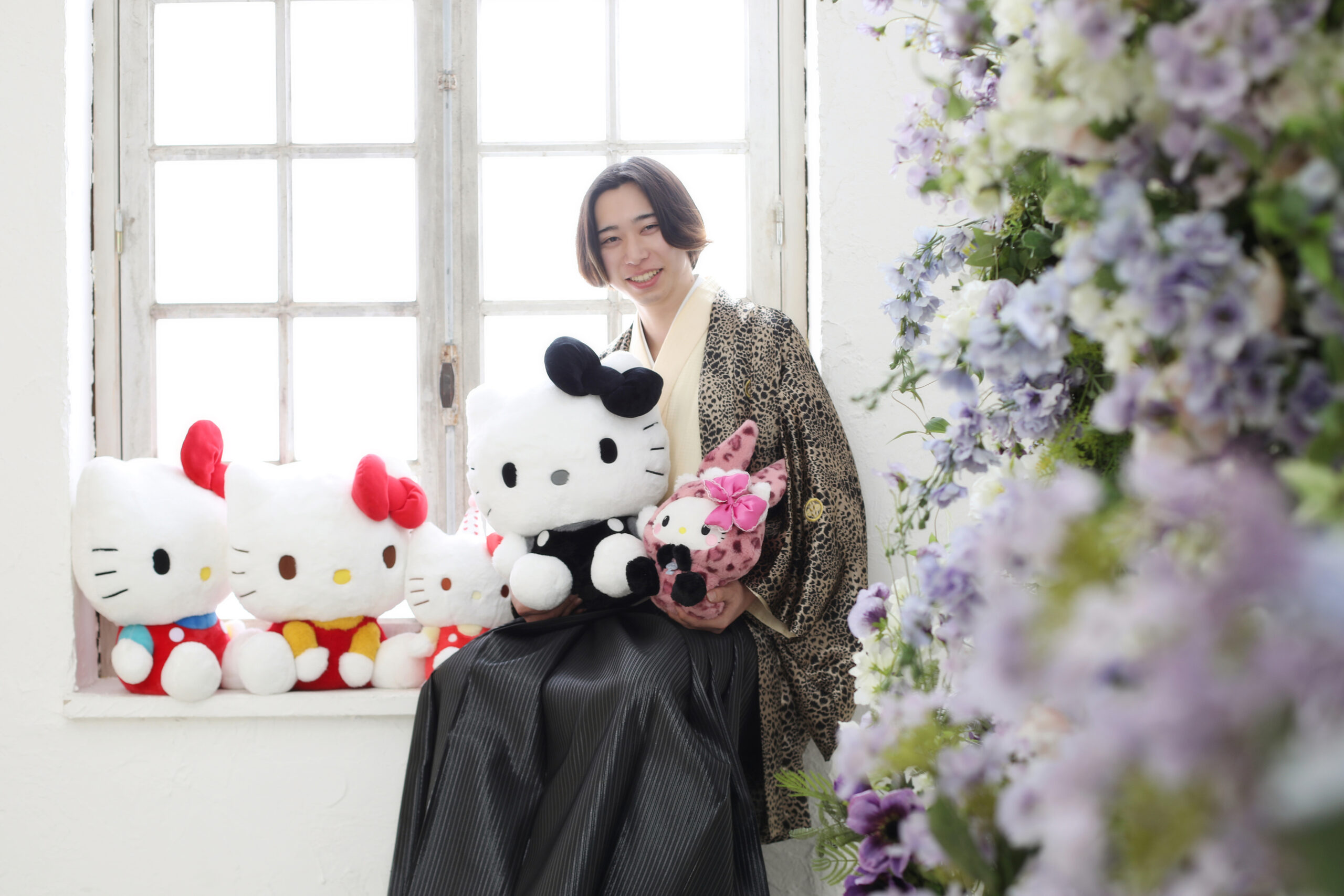キティちゃんに囲まれているヒョウ柄の羽織袴を着た20歳の