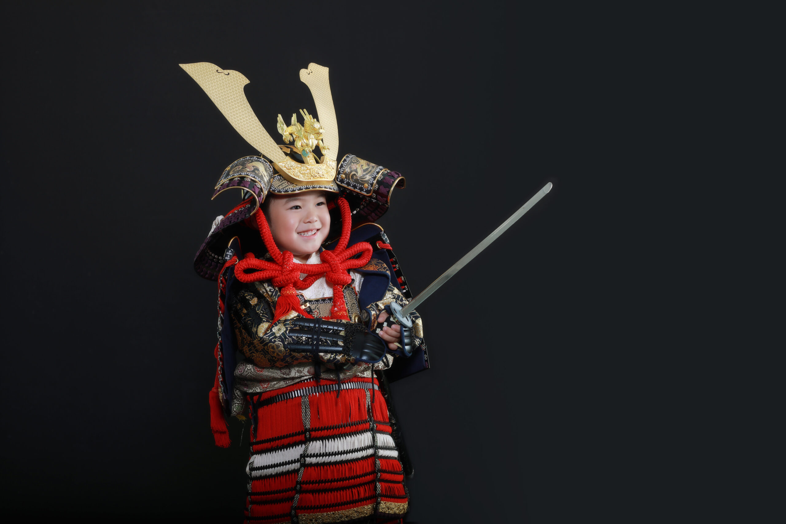 赤い鎧兜を着た五歳男の子の七五三記念写真