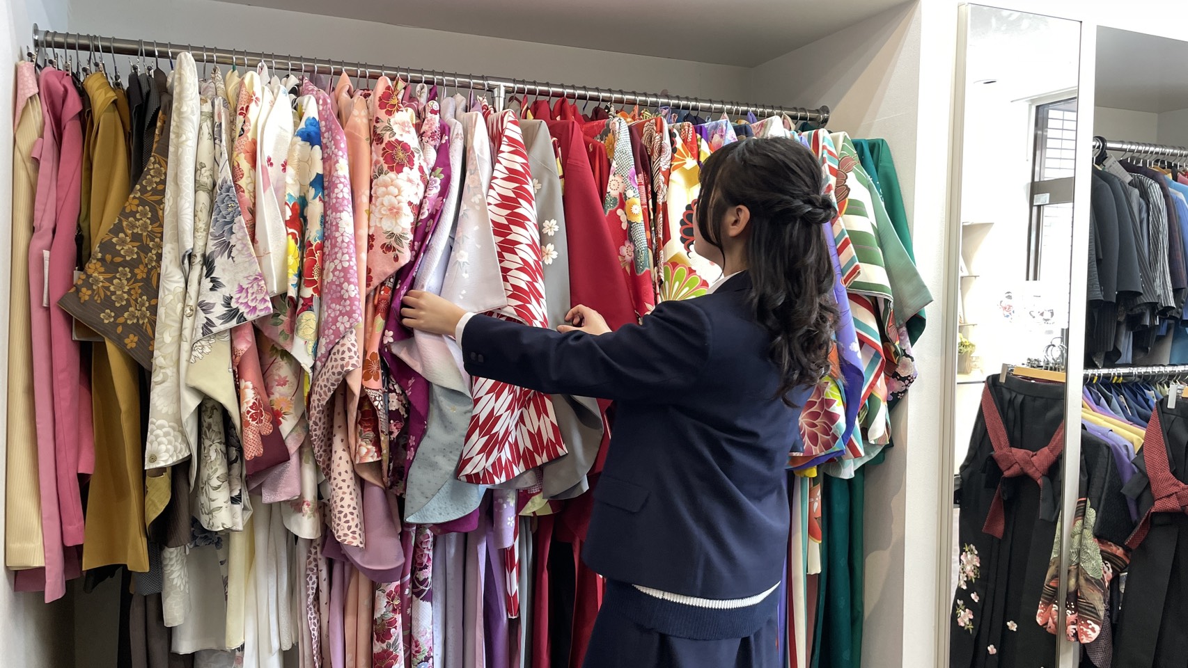 制服を着た高校3年生の女の子が高校生特典の袴を選んでいる様子